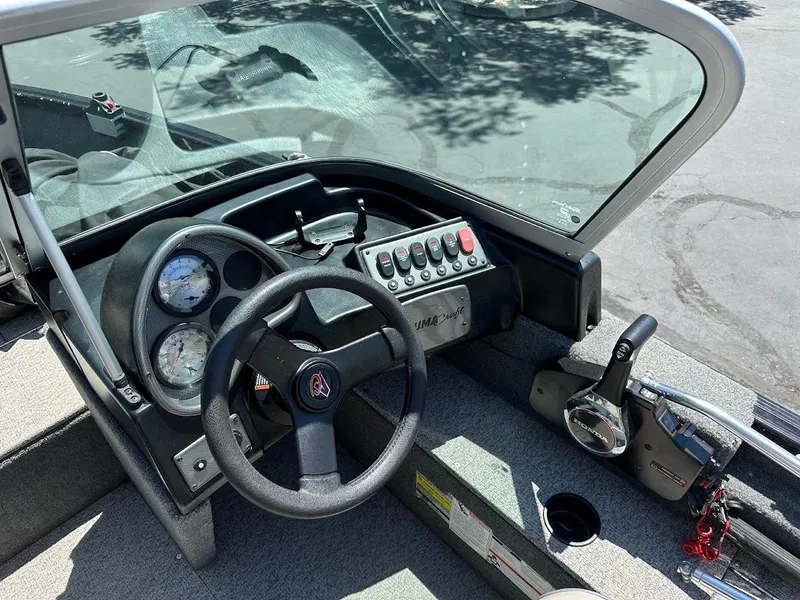 Slide: The Image of 2020 Alumacraft Classic 165 boat dashboard with steering wheel and control panel. - 19