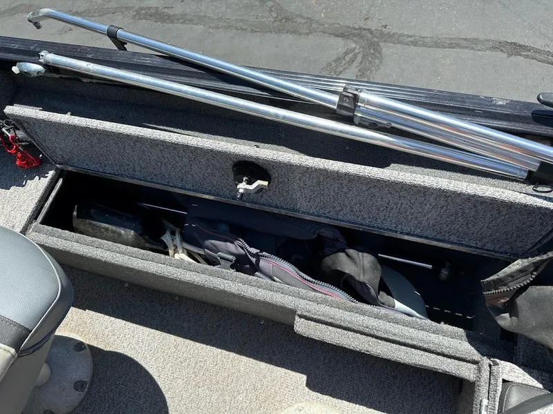 Slide: The Image of 2020 Alumacraft Classic 165 boat storage compartment with fishing gear and rods. - 26