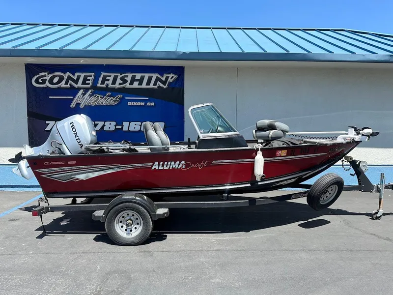 Slide: The Image of 2020 Alumacraft Classic 165 fishing boat on trailer, displayed outdoors. - 28