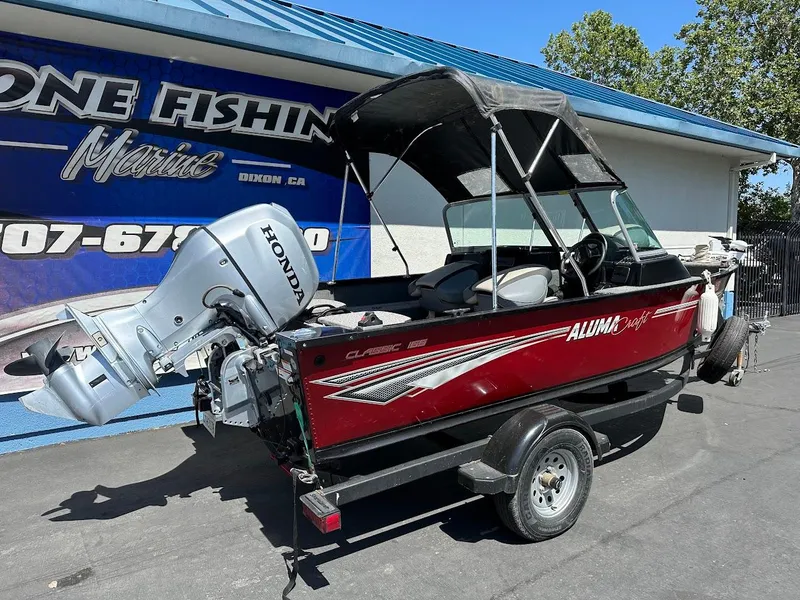 Slide: The Image of 2020 Alumacraft Classic 165 boat with Honda outboard motor, parked at a marina. - 9