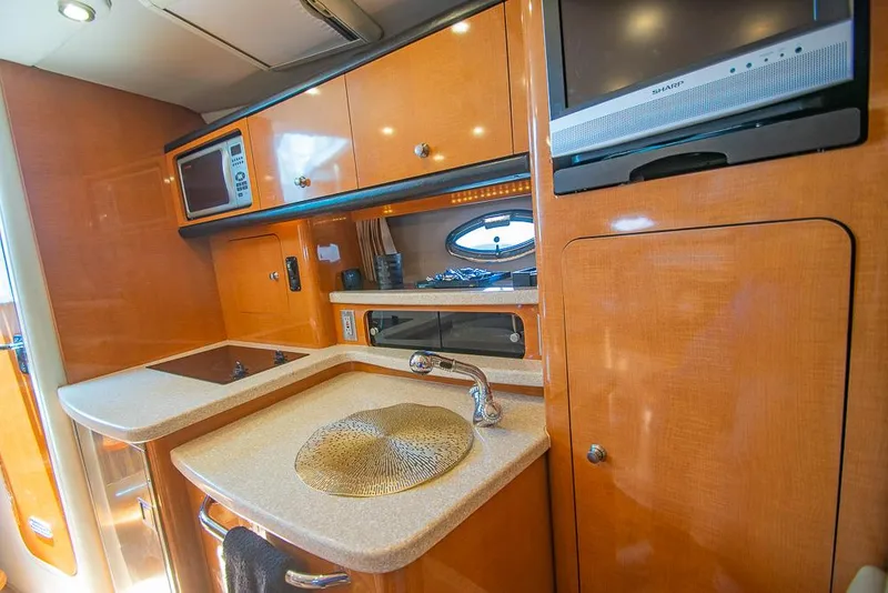 Slide: The Image of 2007 Chaparral Signature 310 yacht kitchen with sink, microwave, and TV. - 13