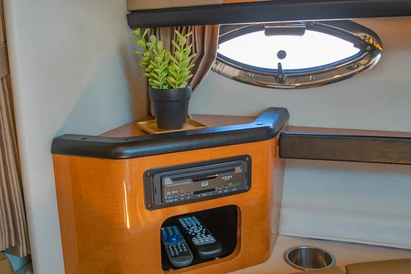 Slide: The Image of 2007 Chaparral Signature 310 cabin interior with porthole, plant, and entertainment controls. - 20