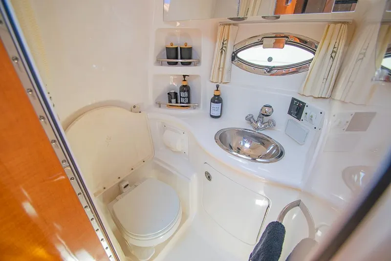 Slide: The Image of 2007 Chaparral Signature 310 bathroom with sink, toilet, and storage shelves. - 25
