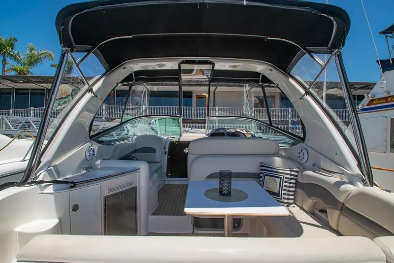 Slide: The Image of 2007 Chaparral Signature 310 yacht interior with seating and table, docked at marina. - 8