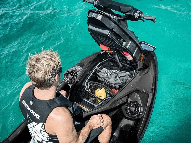 Slide: The Image of 2024 Sea-Doo GTX 230 iBR iDF with storage open, on turquoise water. - 5
