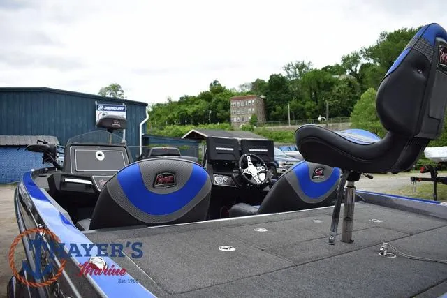 Slide: The Image of 2021 Ranger Z521L boat with blue and black seats, docked near a blue building. - 14