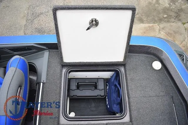 Slide: The Image of 2021 Ranger Z521L boat storage compartment with lock, containing a toolbox and blue bag. - 46