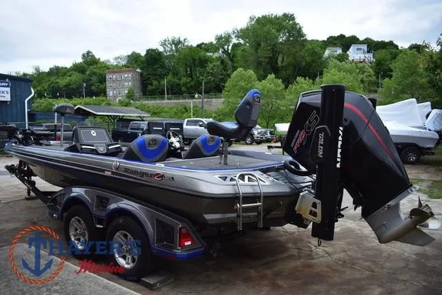 Slide: The Image of 2021 Ranger Z521L boat with dual seats and powerful outboard motor, parked outdoors. - 5
