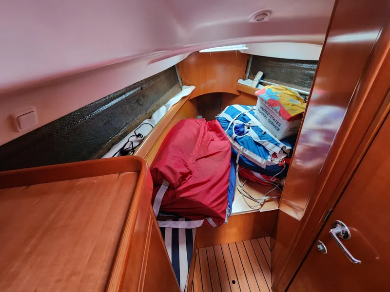 Slide: The Image of Cabin interior of 2003 Beneteau First 40.7 yacht with wooden finish and stored gear. - 19