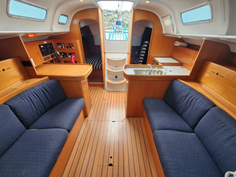 Slide: The Image of Interior of 2003 Beneteau First 40.7 sailboat with wood finish and blue seating. - 20