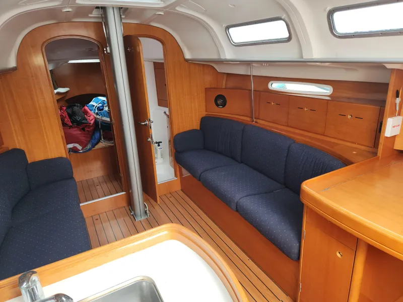 Slide: The Image of Interior of 2003 Beneteau First 40.7 sailboat, featuring cozy seating and wooden cabinetry. - 5
