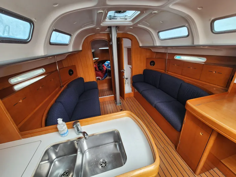 Slide: The Image of Interior of 2003 Beneteau First 40.7 sailboat with wood finish and blue seating. - 6