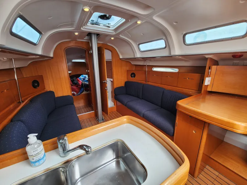 Slide: The Image of Interior of 2003 Beneteau First 40.7 sailboat with wood finish and blue seating. - 8