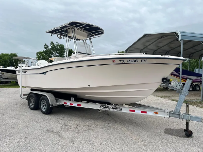 Slide: The Image of 1999 Grady-White 222 boat on trailer, parked outdoors under cloudy sky. - 1