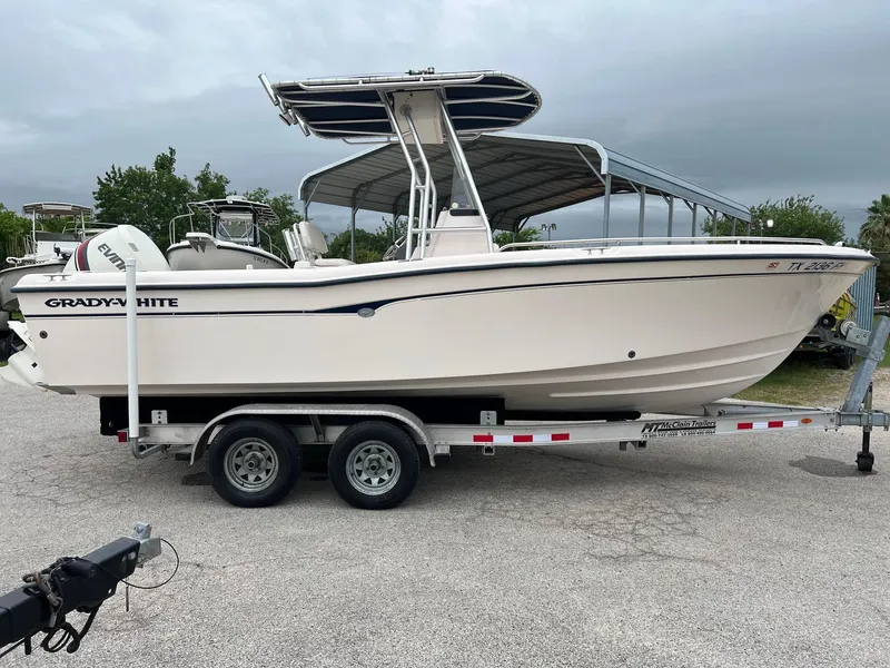 Slide: The Image of 1999 Grady-White 222 boat on trailer, parked outdoors under cloudy sky. - 2