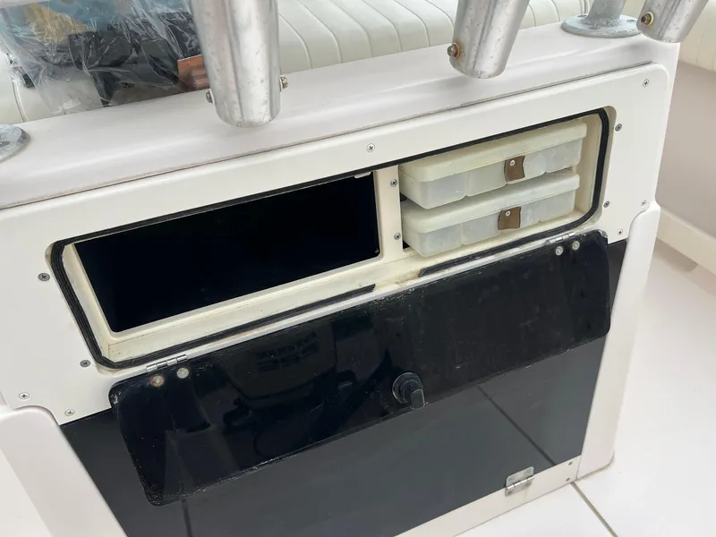 Slide: The Image of 1999 Grady-White 222 boat storage compartment with tackle boxes and rod holders. - 24