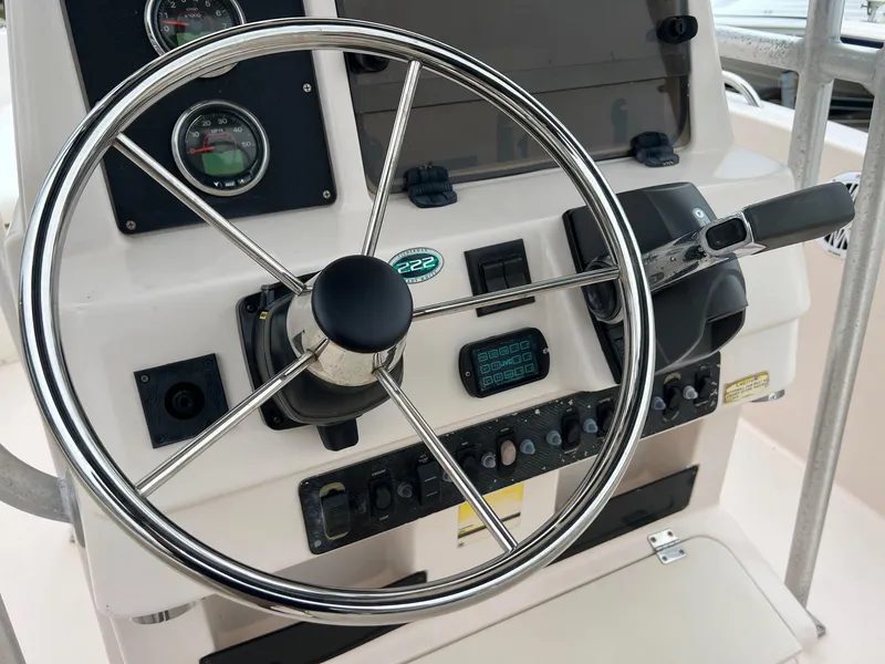 Slide: The Image of Steering wheel and controls of a 1999 Grady-White 222 boat. - 26