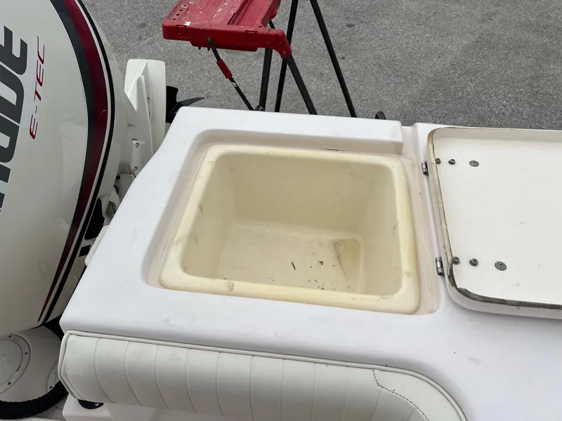 Slide: The Image of 1999 Grady-White 222 boat with open storage compartment and Evinrude E-TEC engine. - 8