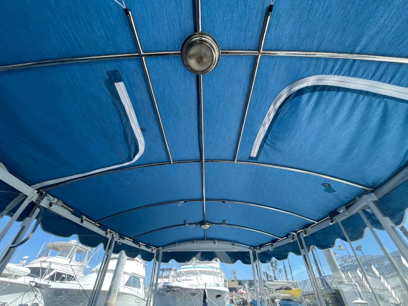 Slide: The Image of Blue canopy of 2014 Duffy 18 Snug Harbor boat, docked with other vessels. - 11