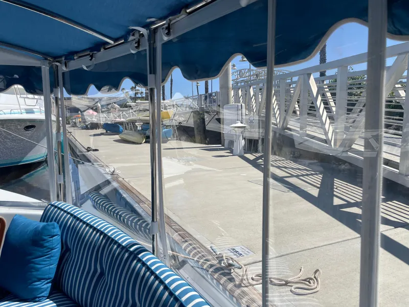 Slide: The Image of 2014 Duffy 18 Snug Harbor boat interior with striped seating, dockside view. - 15