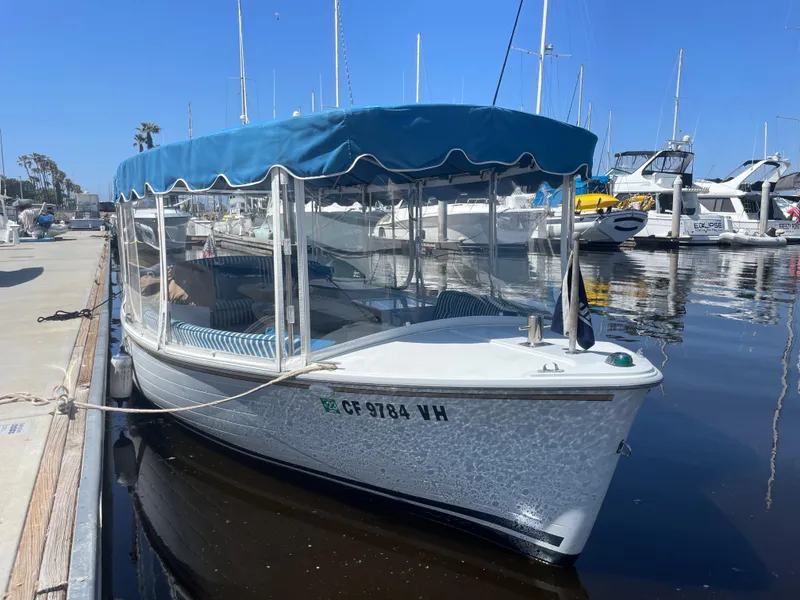 Slide: The Image of 2014 Duffy 18 Snug Harbor boat docked with blue canopy in marina. - 4
