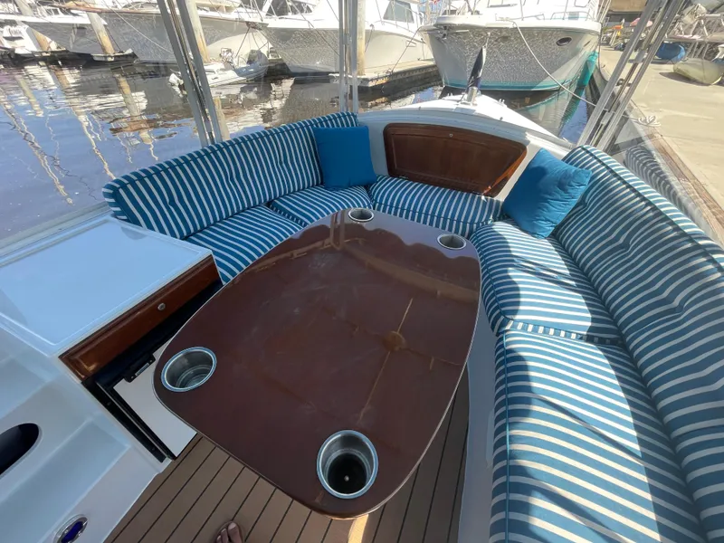 Slide: The Image of 2014 Duffy 18 Snug Harbor boat interior with striped seating and wooden table. - 9