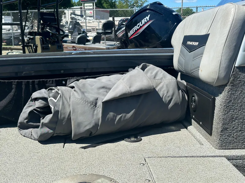Slide: The Image of 2018 Tracker Targa V-19 WT boat interior with rolled-up cover and Mercury engine. - 13