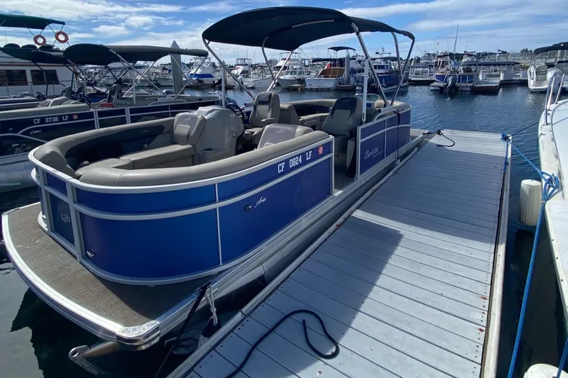 Slide: The Image of 2023 Barletta ARIA 22QC pontoon boat on trailer, parked outdoors. - 1