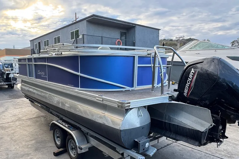 Slide: The Image of 2023 Barletta ARIA 22QC pontoon boat on trailer, featuring a Mercury outboard motor. - 11