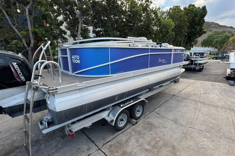 Slide: The Image of 2023 Barletta ARIA 22QC pontoon boat on trailer, parked outdoors. - 16