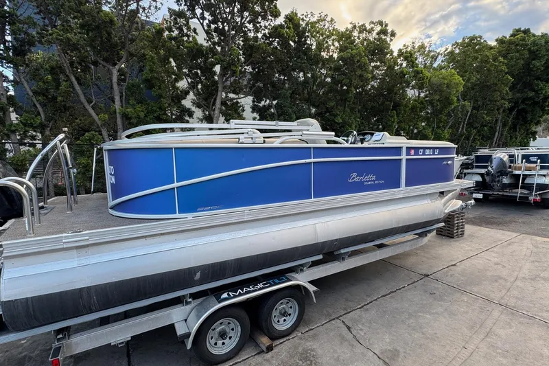 Slide: The Image of 2023 Barletta ARIA 22QC pontoon boat on trailer, parked outdoors. - 17