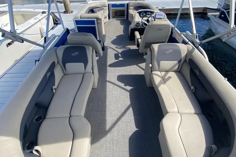 Slide: The Image of 2023 Barletta ARIA 22QC pontoon boat on trailer, parked outdoors. - 3