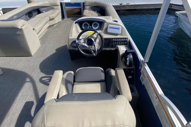 Slide: The Image of 2023 Barletta ARIA 22QC pontoon boat on trailer, parked outdoors. - 4