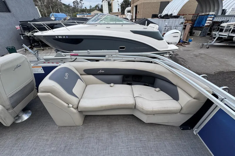 Slide: The Image of 2023 Barletta ARIA 22QC pontoon boat with beige seating, docked near other boats. - 60