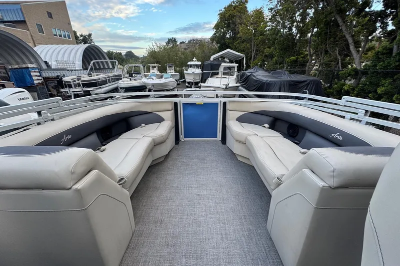 Slide: The Image of 2023 Barletta ARIA 22QC pontoon boat with spacious seating, docked among other boats. - 68