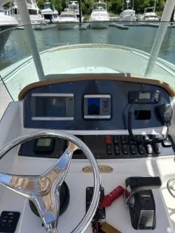 Slide: The Image of 2008 Chris-Craft Catalina 26 helm with steering wheel and navigation controls. - 11