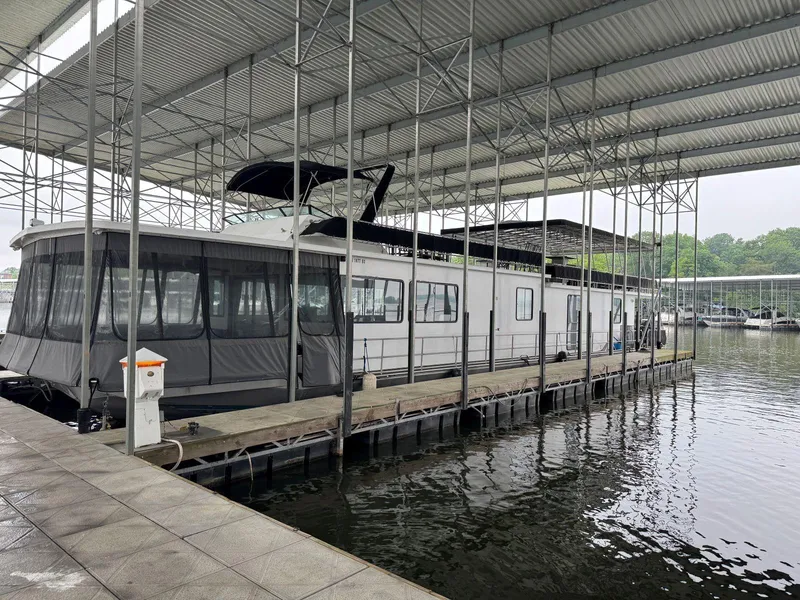 Slide: The Image of 1986 Stardust Cruisers 18 X 80 houseboat docked under a covered marina. - 1