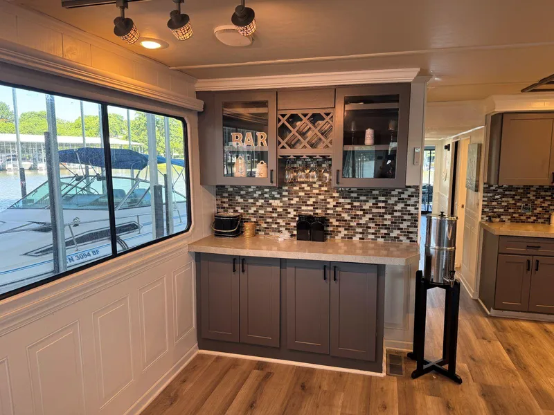 Slide: The Image of 1986 Stardust Cruisers houseboat interior with modern bar area, wood flooring, and large window view. - 13