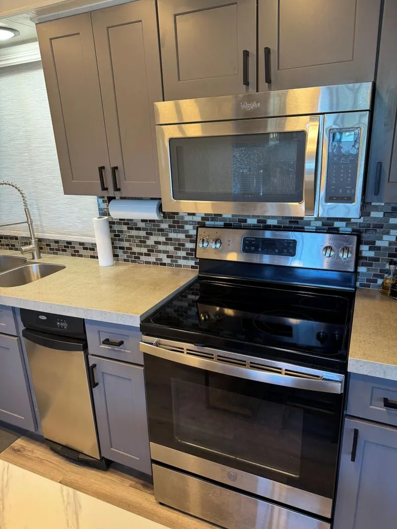 Slide: The Image of Modern kitchen in 1986 Stardust Cruisers houseboat with stainless steel appliances and mosaic backsplash. - 16