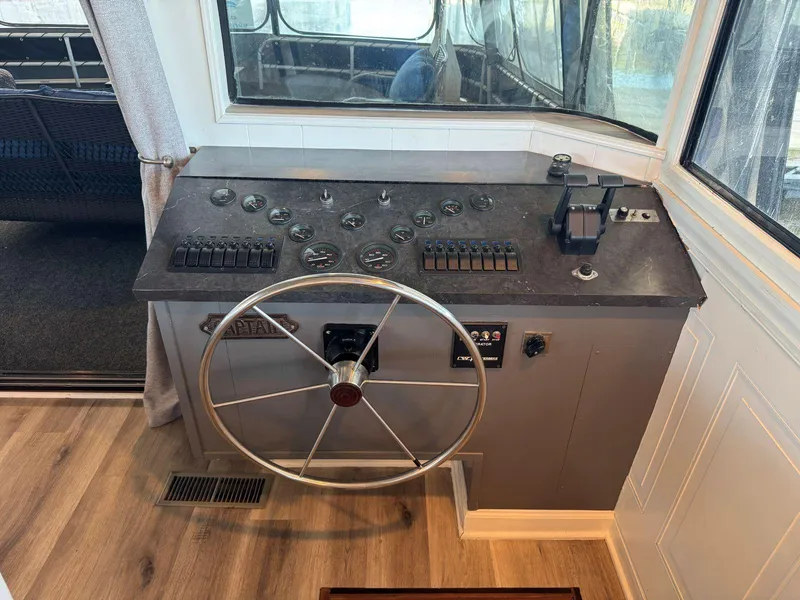 Slide: The Image of Control panel of a 1986 Stardust Cruisers 18 X 80 houseboat with steering wheel and gauges. - 18