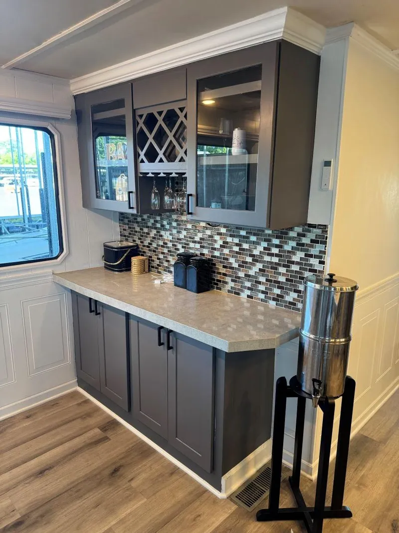 Slide: The Image of Modern kitchen area in a 1986 Stardust Cruisers 18 X 80 houseboat with sleek cabinetry and backsplash. - 19