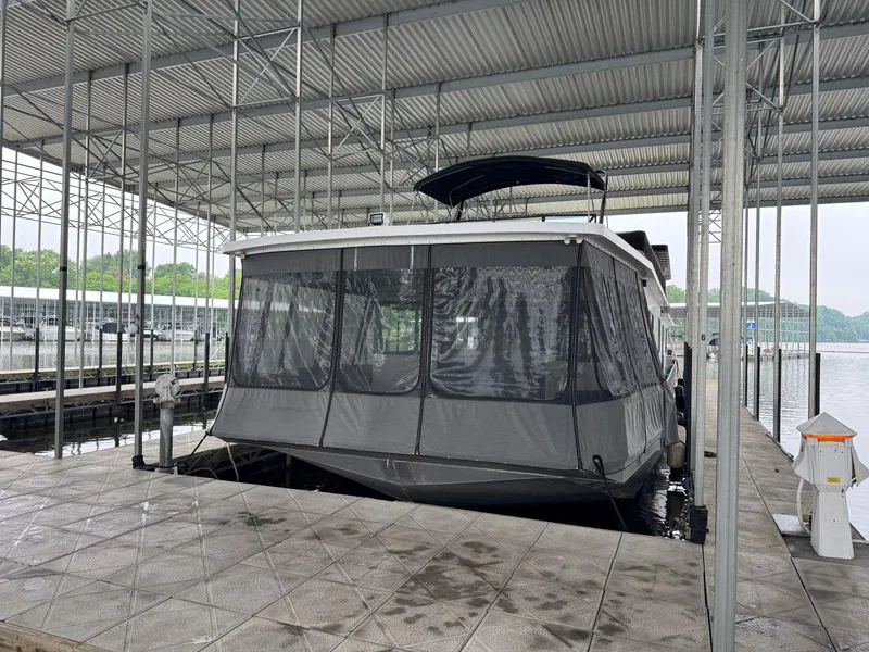 Slide: The Image of 1986 Stardust Cruisers 18 X 80 houseboat docked under a covered marina. - 2