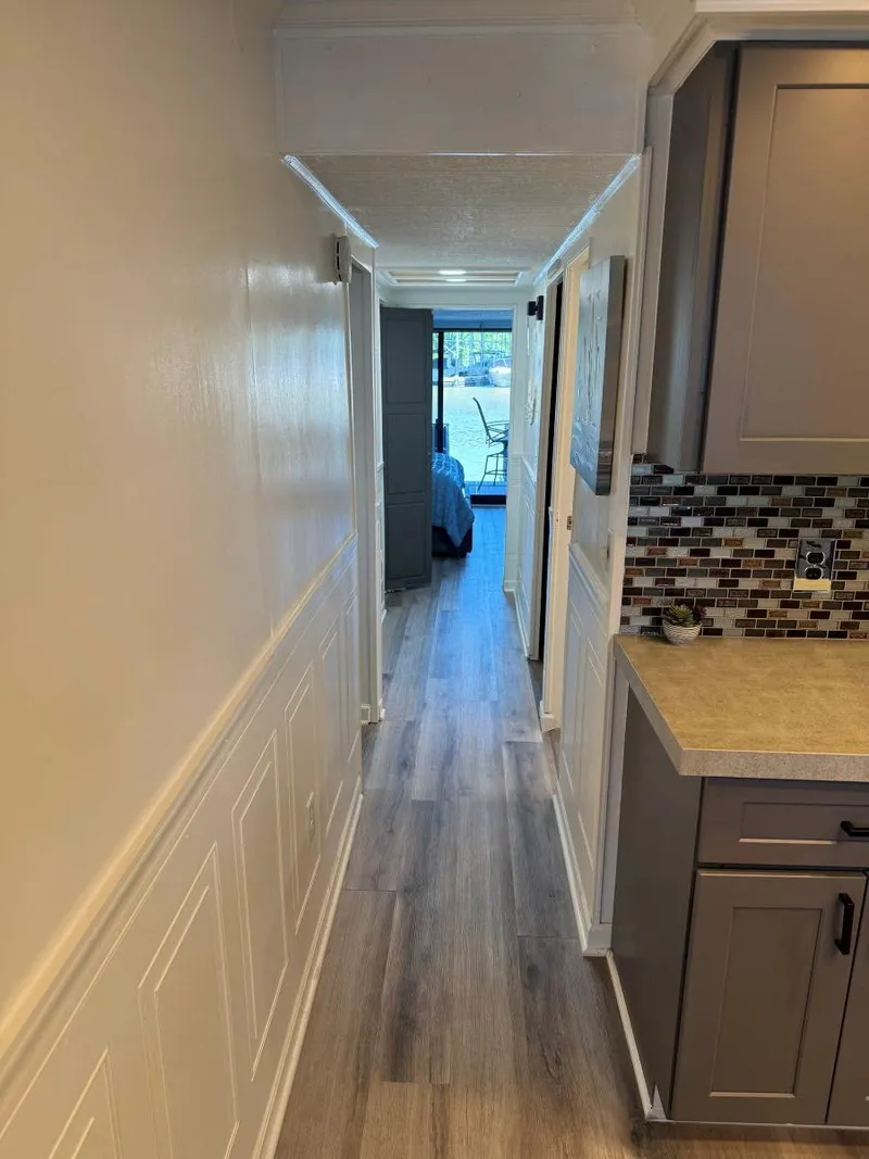 Slide: The Image of Narrow hallway in a 1986 Stardust Cruisers 18 X 80 houseboat, featuring modern kitchen cabinetry. - 20