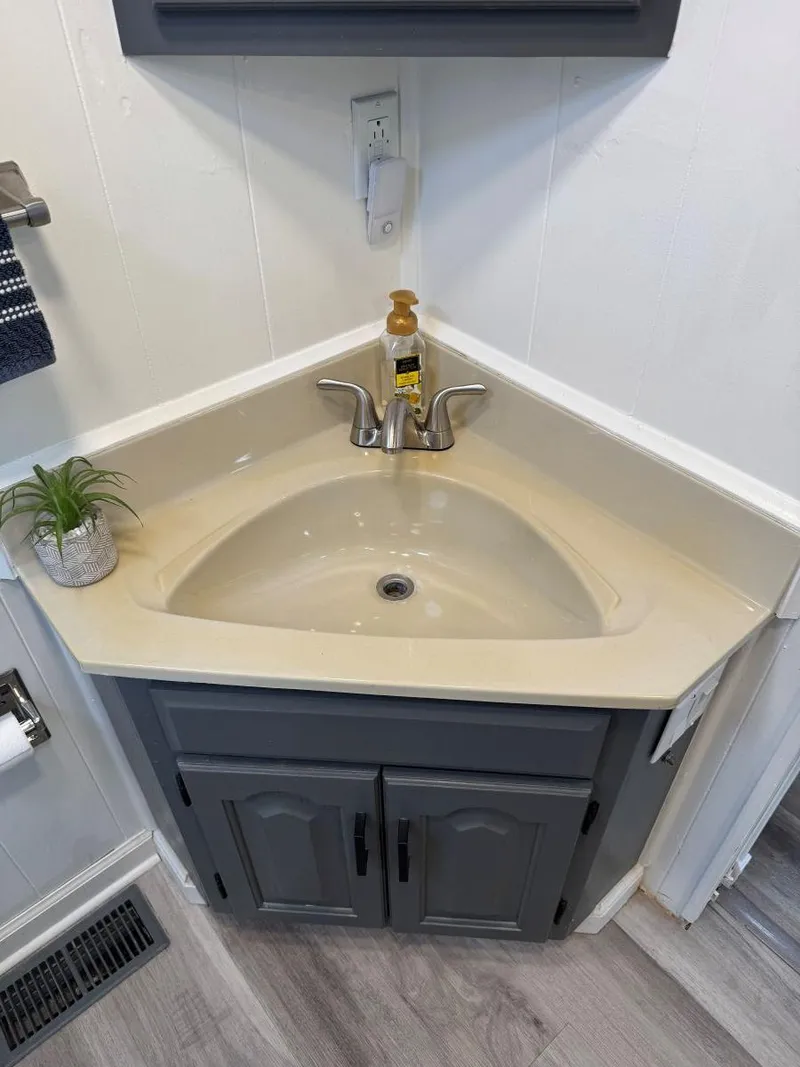 Slide: The Image of Corner sink with beige countertop and gray cabinet in a 1986 Stardust Cruisers houseboat. - 24