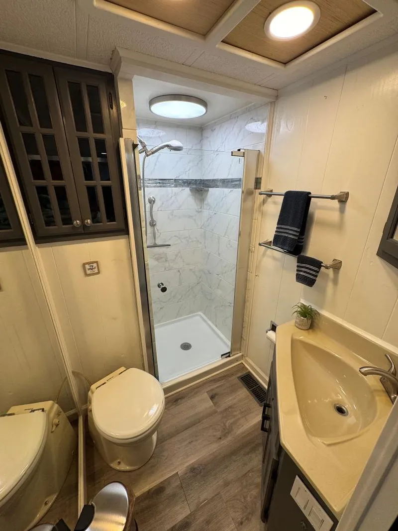 Slide: The Image of 1986 Stardust Cruisers houseboat bathroom with shower, sink, and toilet. - 25