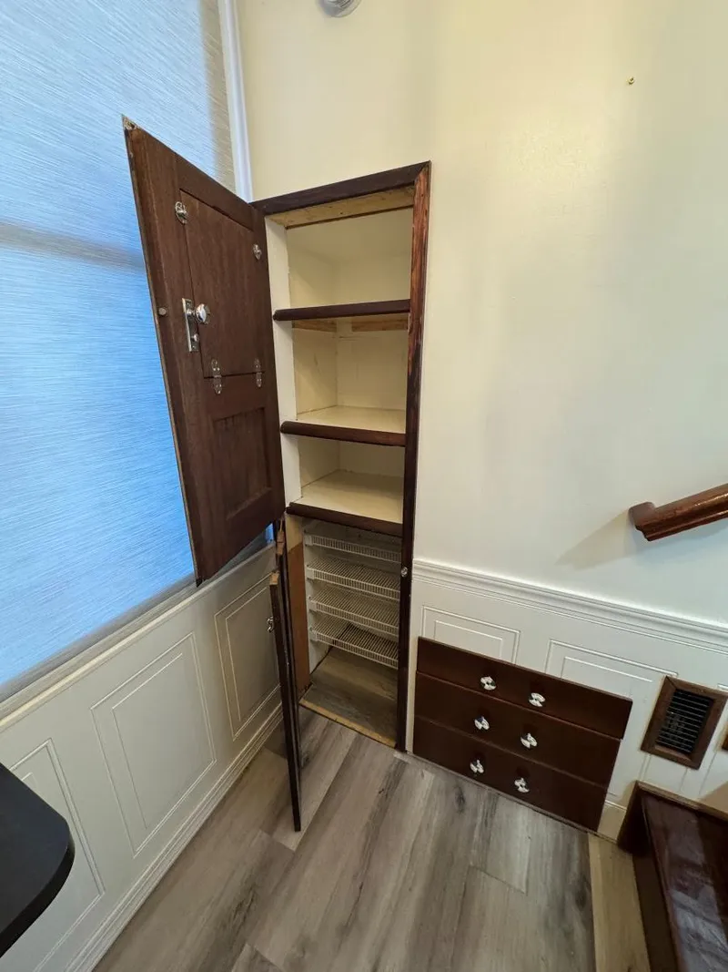 Slide: The Image of 1986 Stardust Cruisers houseboat interior with open wooden cabinet and drawers. - 29