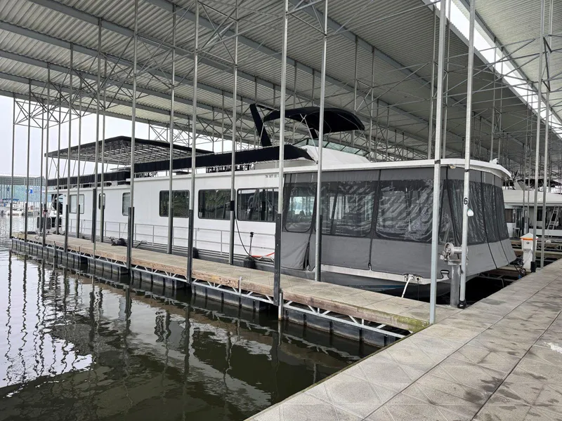 Slide: The Image of 1986 Stardust Cruisers 18 X 80 houseboat docked in a covered marina. - 3