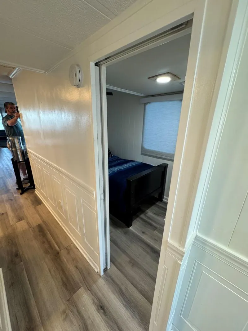 Slide: The Image of Hallway view inside a 1986 Stardust Cruisers 18 X 80 houseboat, featuring a bedroom entrance. - 30