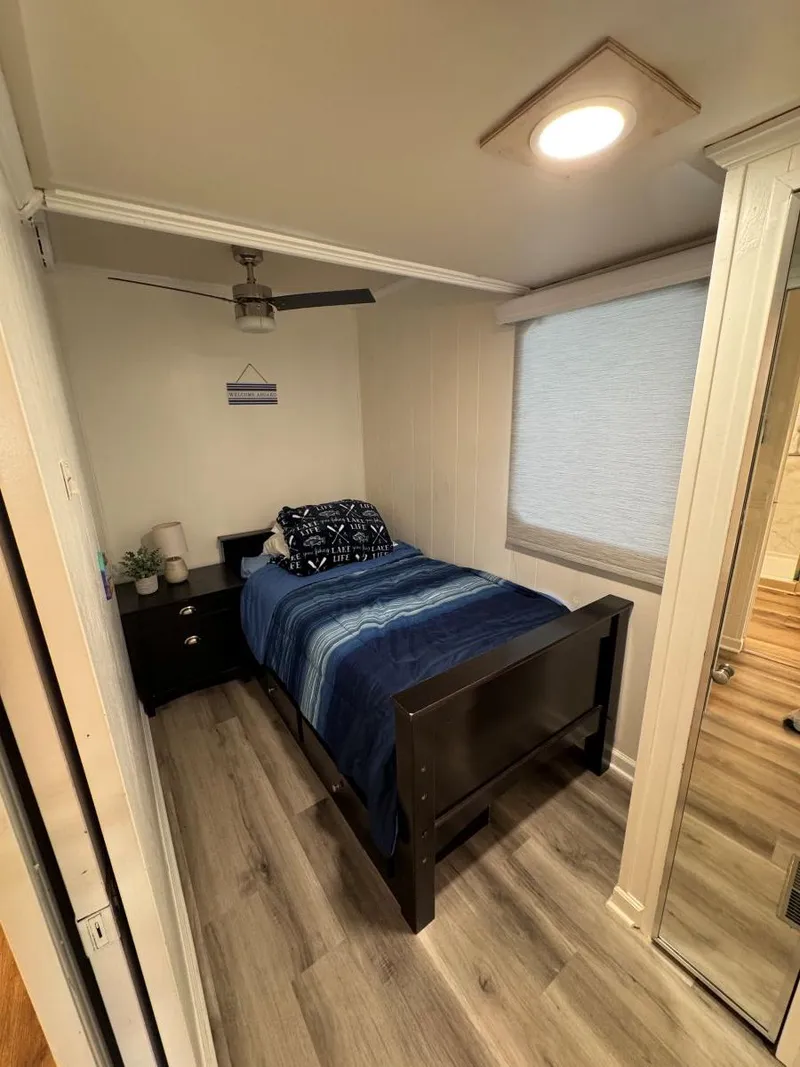 Slide: The Image of Small bedroom in 1986 Stardust Cruisers houseboat with modern decor and wooden flooring. - 31