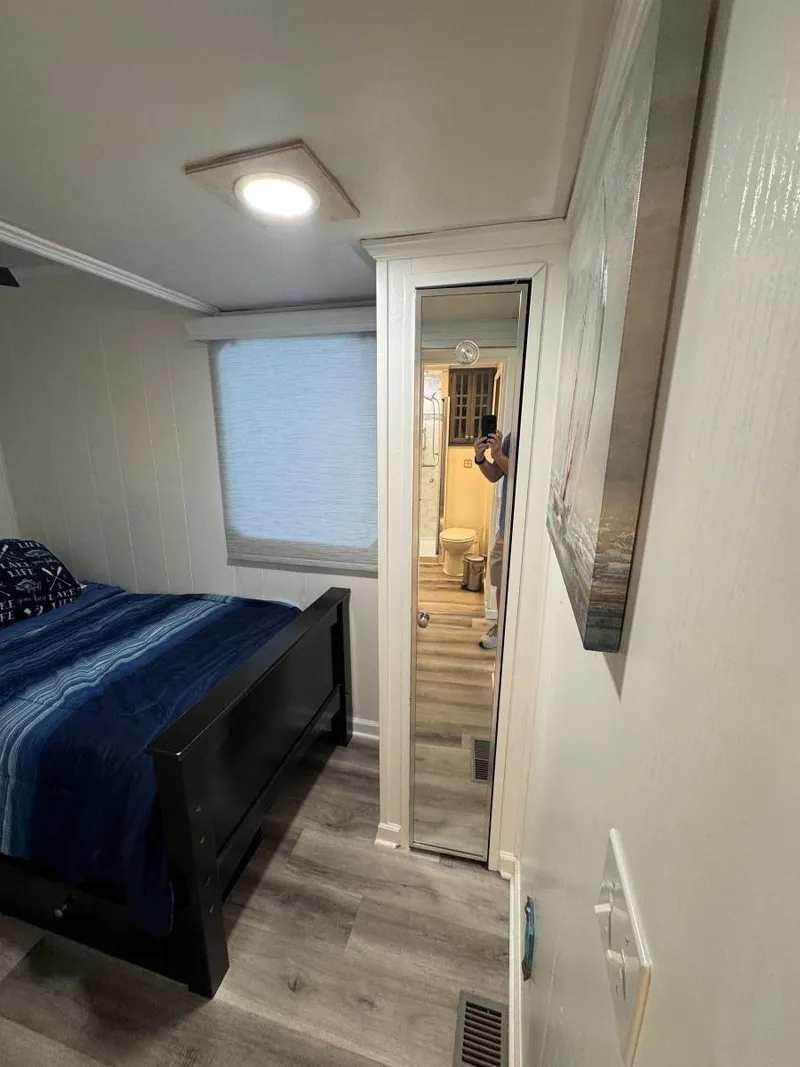 Slide: The Image of 1986 Stardust Cruisers 18 X 80 Houseboat bedroom with bed, mirror, and window. - 32